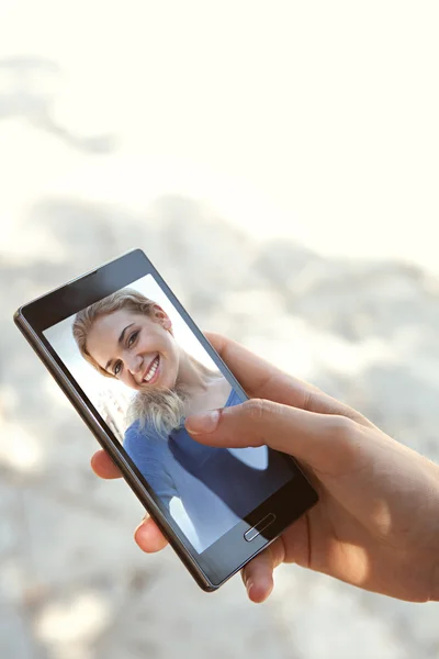 Женщина держит руку и с помощью сенсорного экрана смартфона — стоковое фото