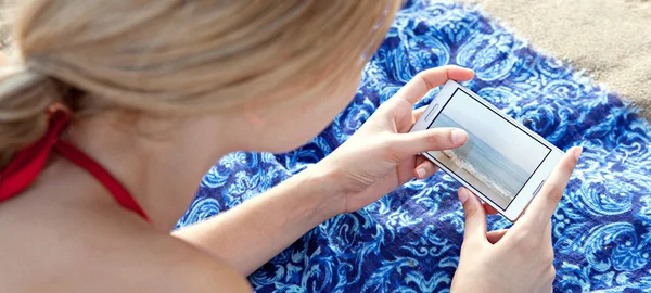 Kobieta za pomocą smartfona na plaży — Zdjęcie stockowe