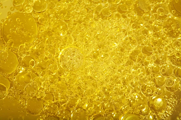 Background detail view of golden shining yellow oil boiling — Stockfoto