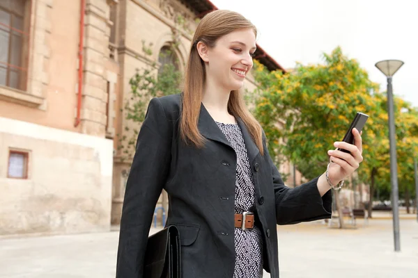 Mujer de negocios sosteniendo y usando un teléfono inteligente — Foto de Stock