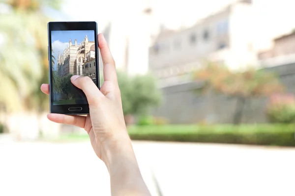 Woman taking pictures of a characterful architecture cathedral — 图库照片