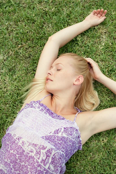 若い女性の緑の芝生の上に敷設 — ストック写真