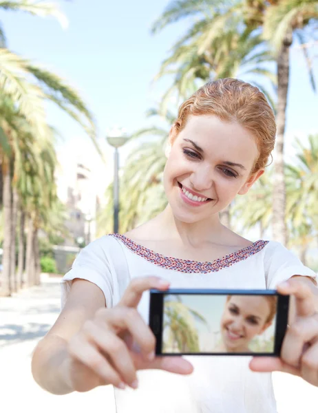 Woman taking a selfie picture of herself on a summer vacation — Stok fotoğraf