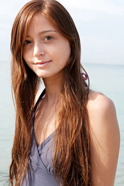 Attractive teenager girl standing on a beach — Stock Photo, Image