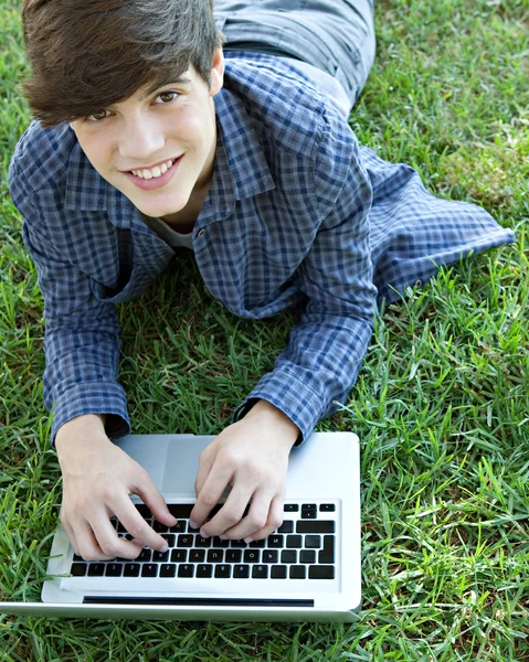 Adolescente estudiante chico mirando hacia arriba a la cámara sonriendo — Foto de Stock