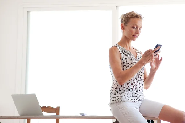 Frau mit Smartphone im Büro — Stockfoto