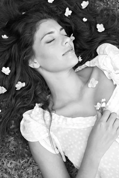 Woman laying in a garden with small flowers — Stock Photo, Image