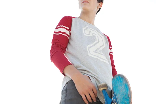 Adolescente ragazzo portando uno skateboard — Foto Stock