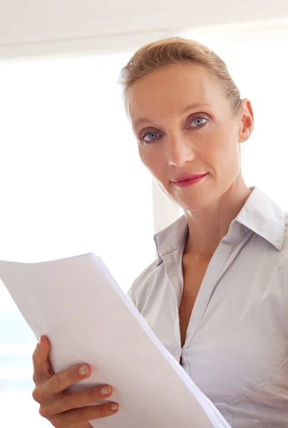 Business woman holding and reading paperwork — Stock Photo, Image