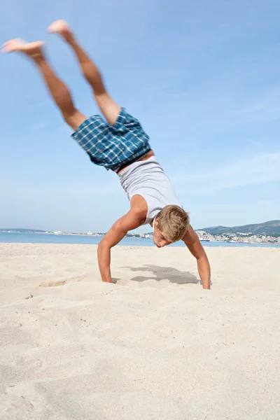 Chico haciendo volteretas con sus piernas en el aire — Foto de Stock