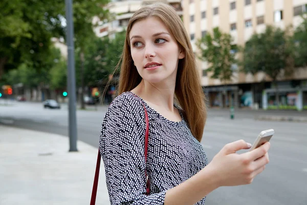 Business woman using a smartphone in city — Stockfoto