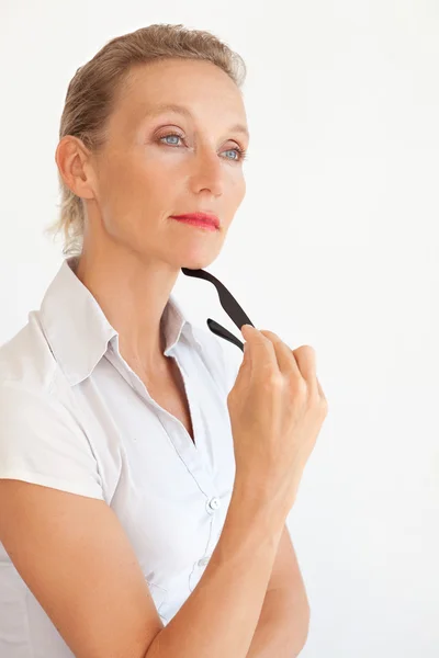 Woman holding her reading glasses in her hand — Stockfoto