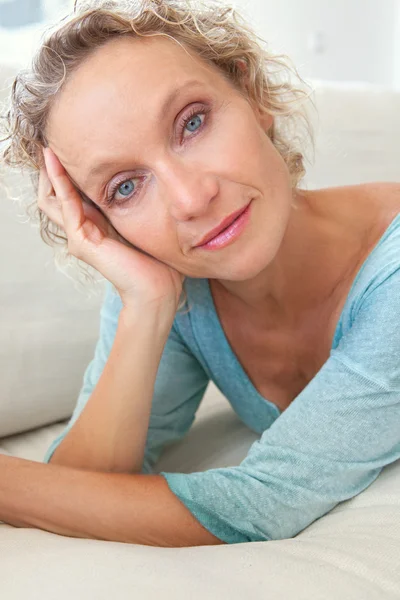 Woman on a white sofa at home — Stock Photo, Image