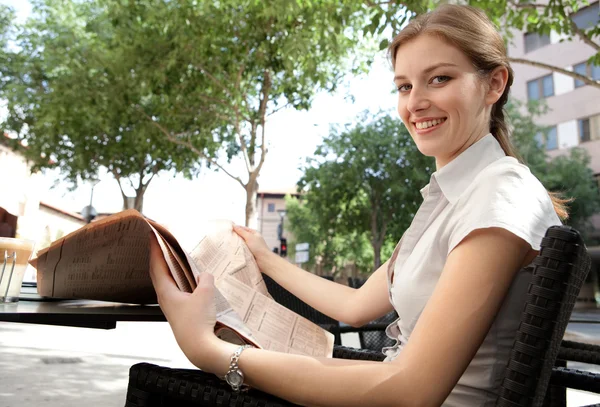 Business woman reading a financial newspaper — Stok fotoğraf