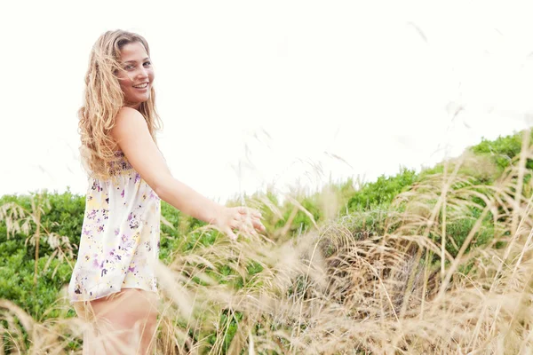 Молода жінка в рослинних дюнах пляжу — стокове фото