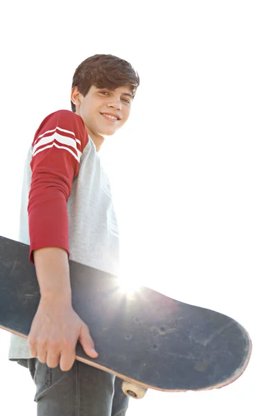 Teenager boy carrying a skateboard — Stockfoto