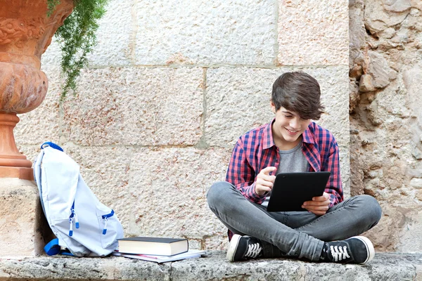 Chico en un campus universitario usando una tableta digital — Foto de Stock