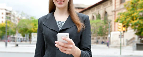 Empresária usando smartphone em uma cidade — Fotografia de Stock