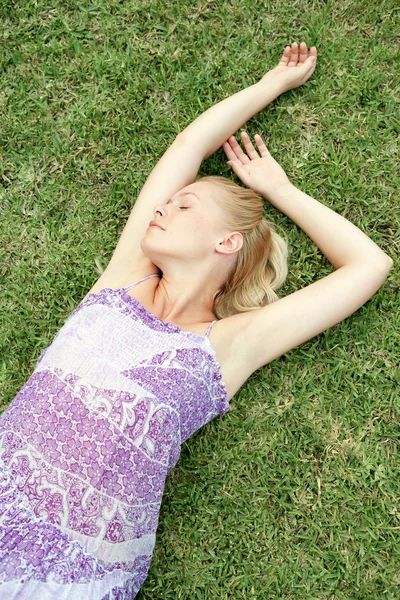 Mladá žena na zelené trávě — Stock fotografie