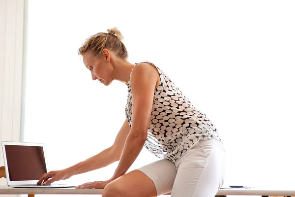 Femme utilisant un ordinateur portable au bureau — Photo