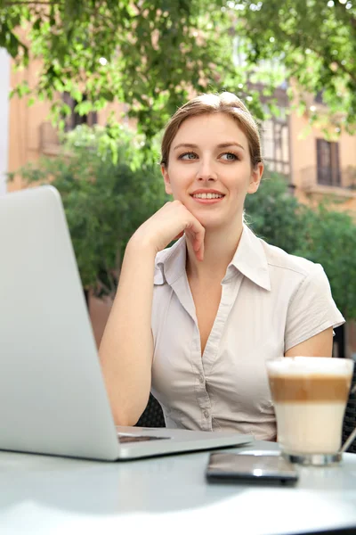 Mulher de negócios em um café usando um computador portátil — Fotografia de Stock