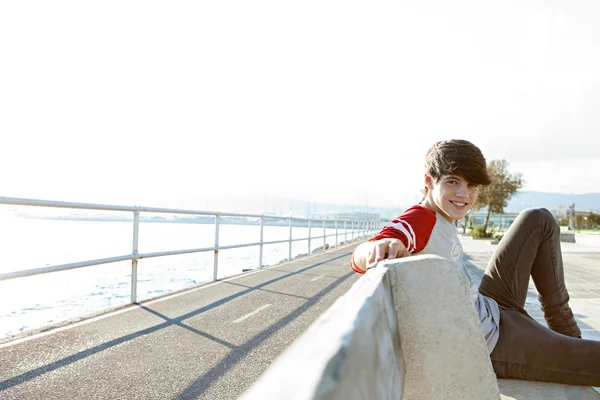 Boy sitting down on a bench — ストック写真