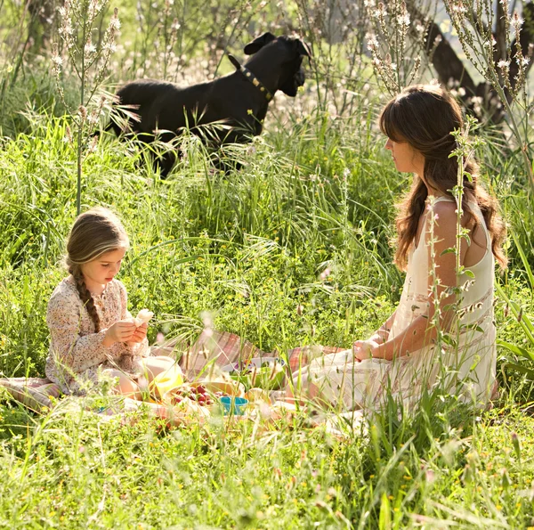 Mère et fille pique-niquer dans un jardin — Photo