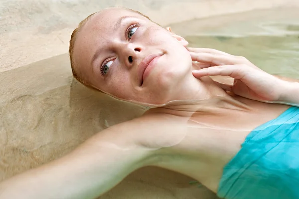 Woman floating and relaxing of a natural swimming pool — Stock fotografie