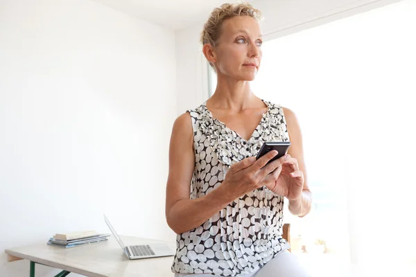 Geschäftsfrau im Büro mit Smartphone — Stockfoto