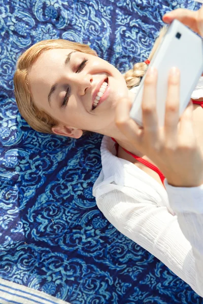 Vrouw met smartphone op het strand — Stockfoto