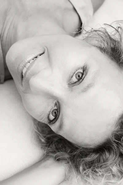 Woman relaxing on a white sofa at home — Stok fotoğraf