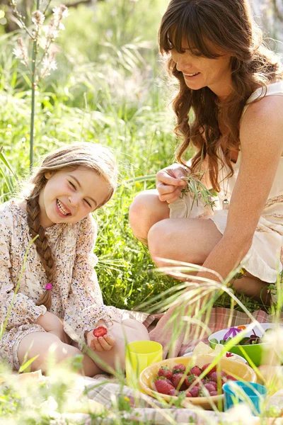 Mother and daughter having a picnic in a garden — ストック写真