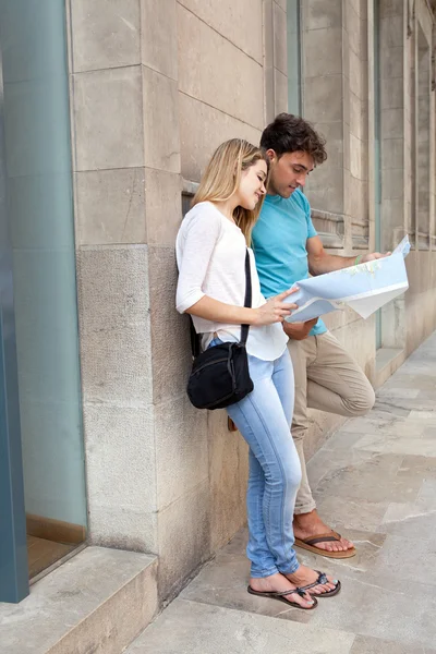 Couple looking and pointing at a map — Stockfoto