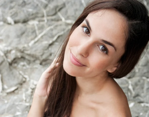 Woman sitting and relaxing on a rock by the sea — Stock Photo, Image