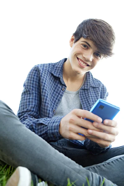 Мальчик с помощью смартфона на траве — стоковое фото