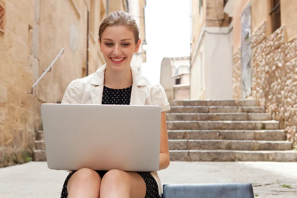 Business woman using a laptop computer outdoors Stockbild