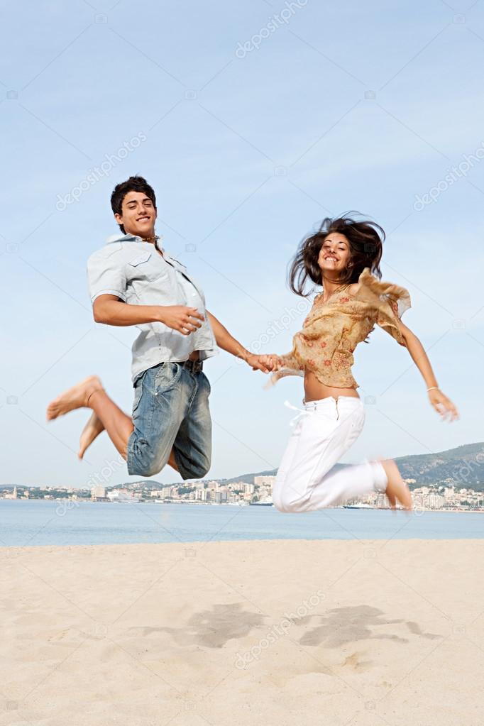 couple holding hands and jumping up in the air
