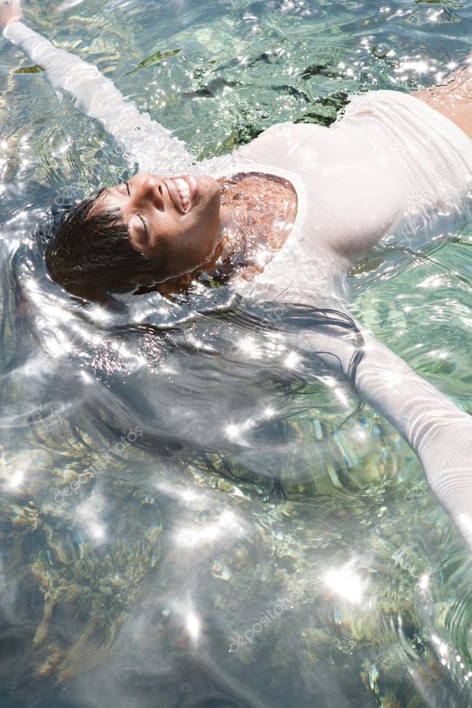 black woman swimming and floating in a sea