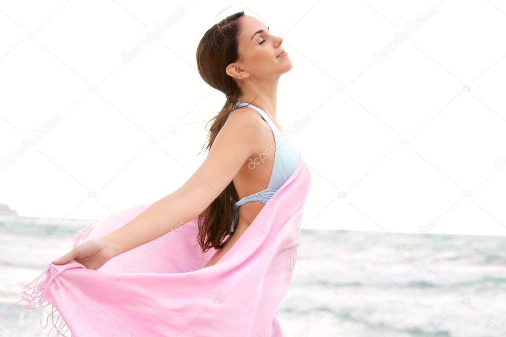 woman on a beach with a pink fabric sarong