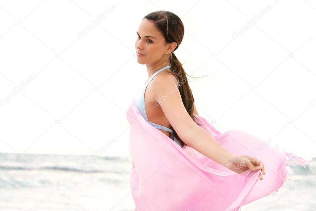 woman on a beach with a pink fabric sarong