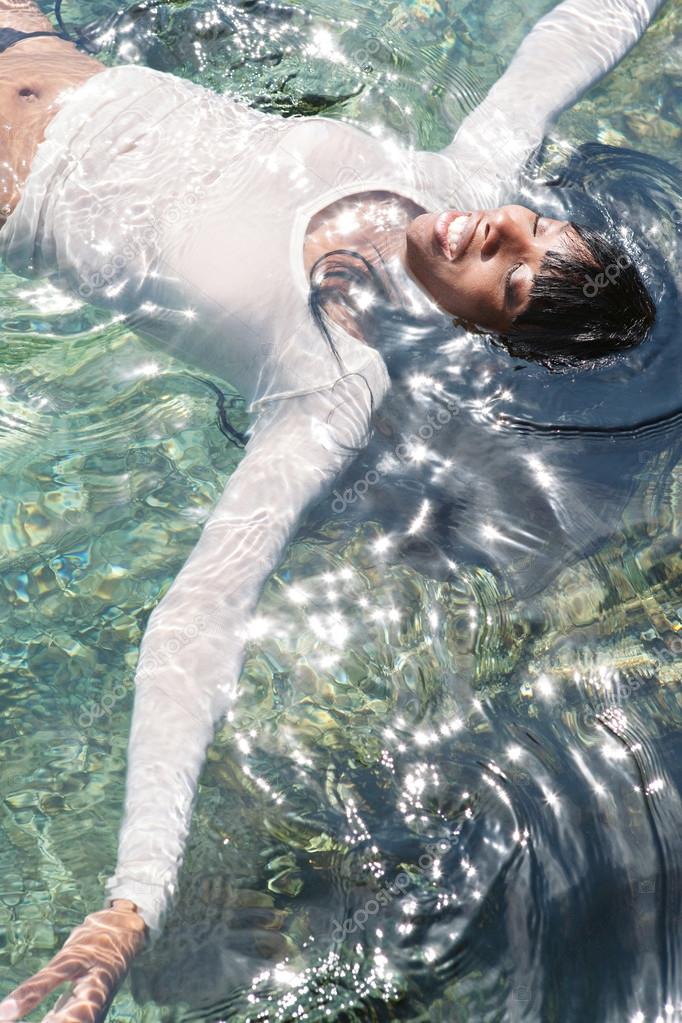 black woman swimming and floating in a sea