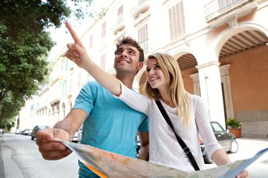 tourist couple with map pointing up