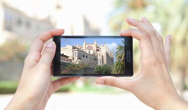 woman taking pictures of a characterful architecture cathedral