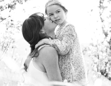 Mother and daughter hugging in a spring field
