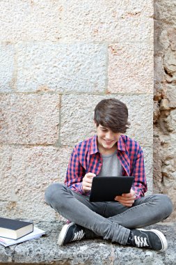 boy using a digital tablet pad to do his homework