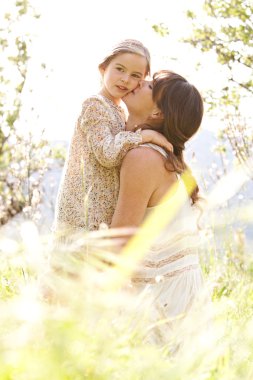 Mother and daughter hugging in a spring field