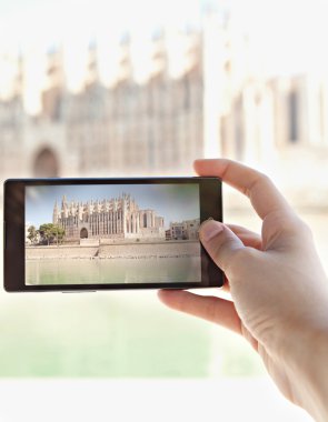 woman taking photos of a monument cathedral