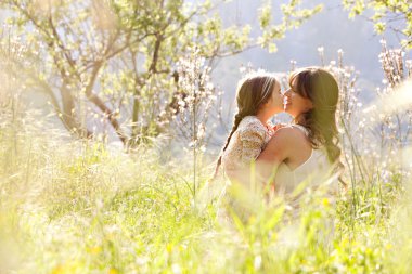 Mother and daughter hugging in a spring field