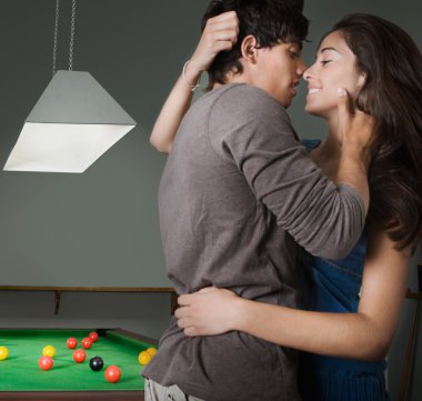 couple hugging and kissing with passion in a bar