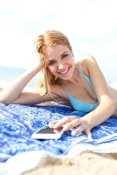 Kvinna som använder smartphone på stranden — Stockfoto